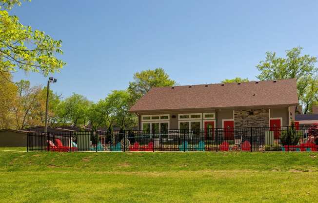 Community pool and pool house at the Retreat at Indian Lake apartments in hendersonville surrounded by black iron fence and lush green grass.