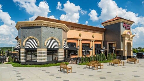 a rendering of a restaurant with tables and chairs in front of a building