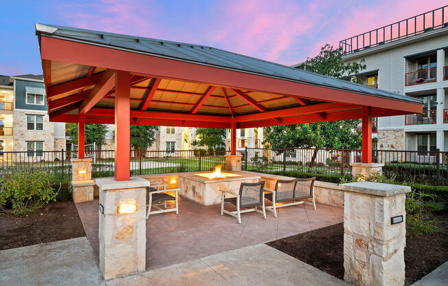 a patio with a fire pit and a red pavilion