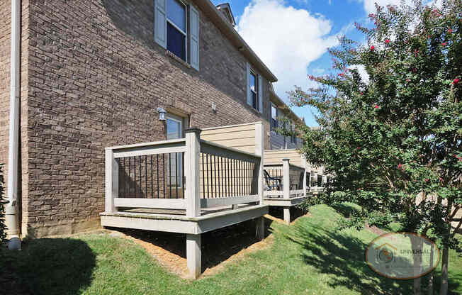 The rear of a row of apartment buildings with patios.