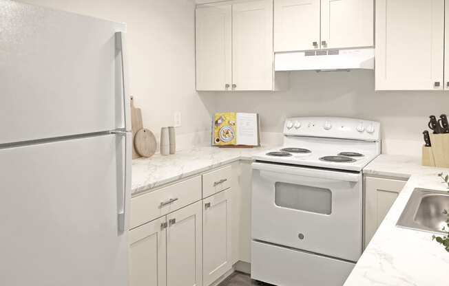 a kitchen with white appliances and white cabinets