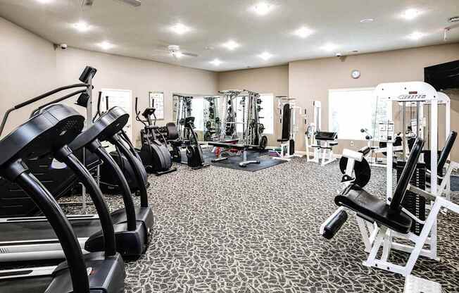 A gym with a variety of equipment including treadmills, weights, and a bench press. at Tranquility Pointe, Nebraska, 68164