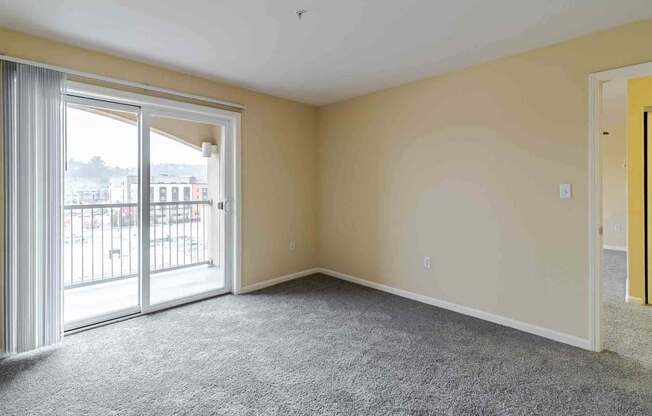 A room with a grey carpet and a yellow door.