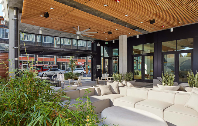 A patio with white couches and a wooden ceiling.