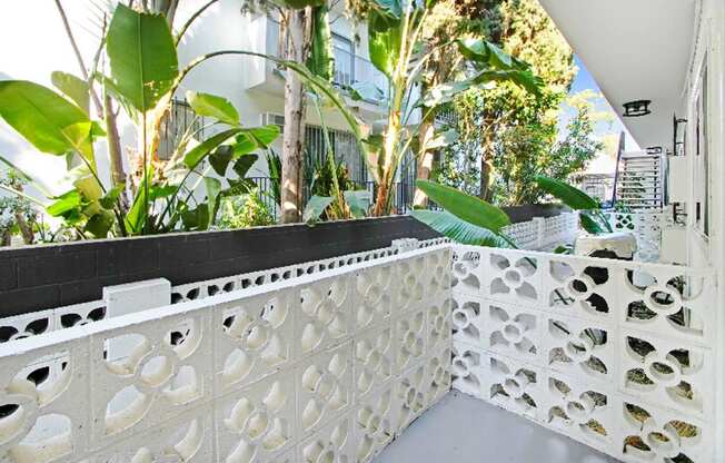 a balcony with a white fence and plants