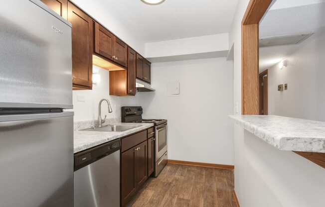 St. Louis Park, MN Courtyard Apartments. a kitchen with wood flooring and white walls