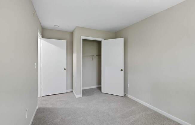 A room with two white doors and a carpeted floor.