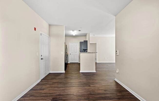 A long hallway with a white door on the left and a white door on the right.