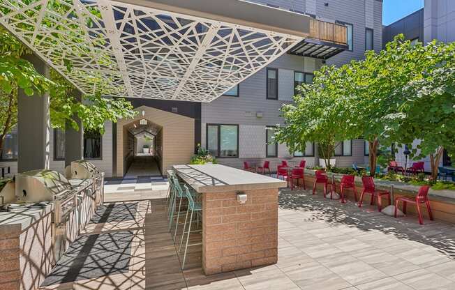 a patio with a bar and chairs and a building