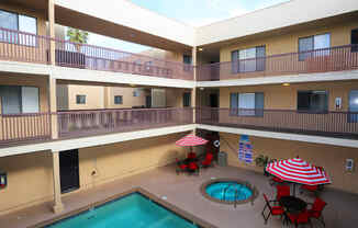 a balcony with a pool and tables with umbrellas