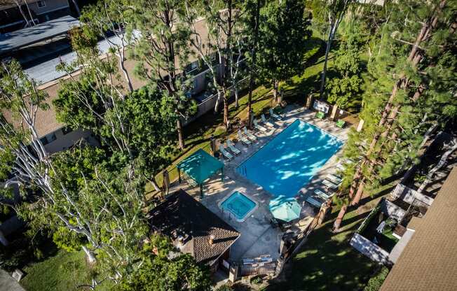 a backyard with a swimming pool and a patio with tables and chairs