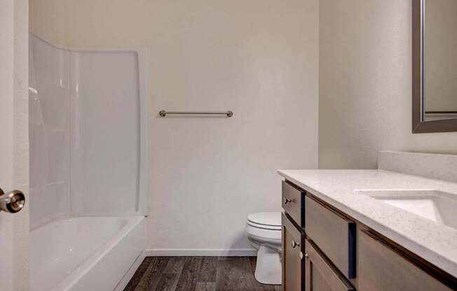 A white bathroom with a toilet, sink, and shower.