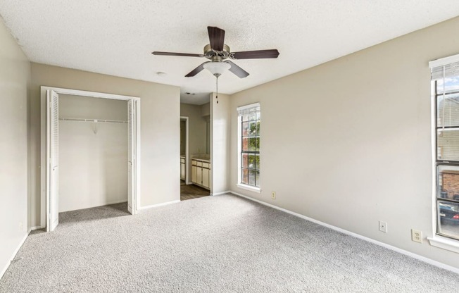 Cozy bedroom with closet and ceiling fan and entry to bathroom at Bandera Crossing apartments in San Antonio, TX