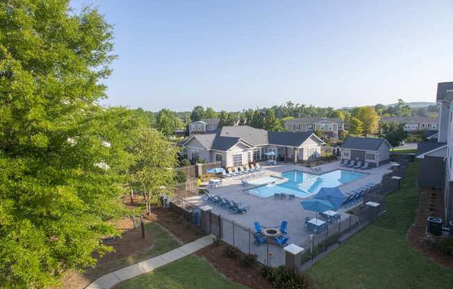 an aerial view of a swimming pool in a backyard with trees