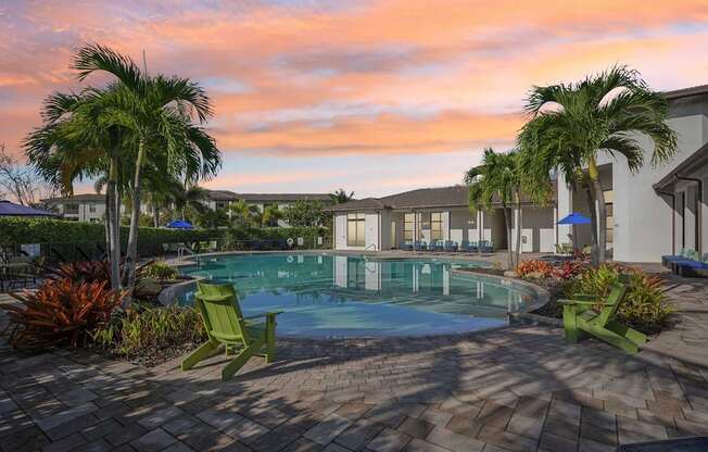 A pool surrounded by palm trees and a sun lounger.