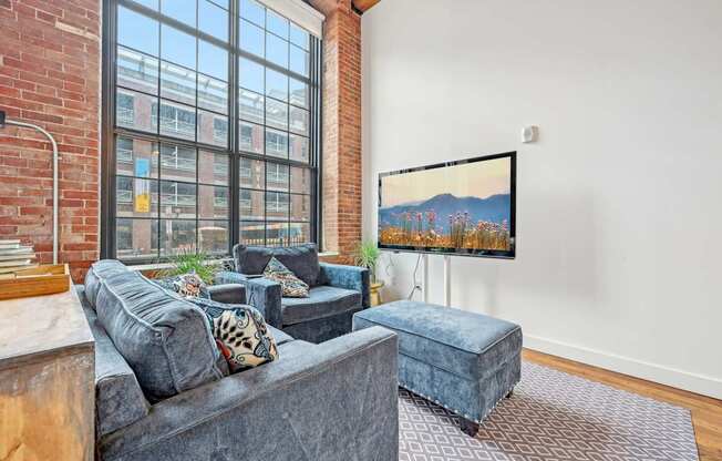 a living room with a large window and a couch and a chair