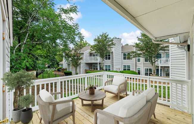A patio with a white railing and furniture.