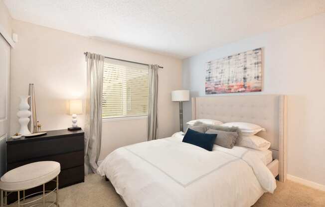 a bedroom with a bed and a dresser and a window