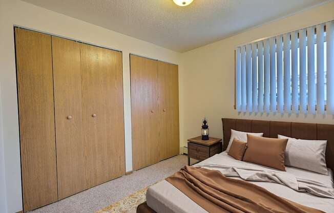 Fargo, ND Saddlebrook Apartments. a bedroom with a bed and two closets