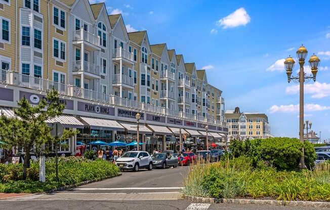 A street view of a hotel with cars parked in front and a clear blue sky.