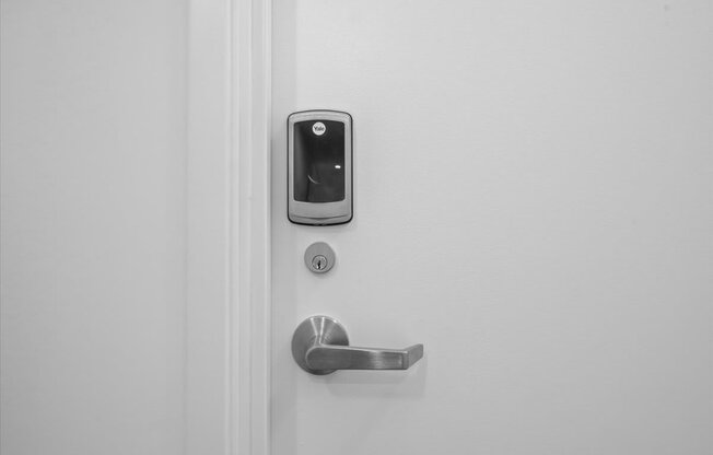 A white door with a silver handle and a keypad lock.