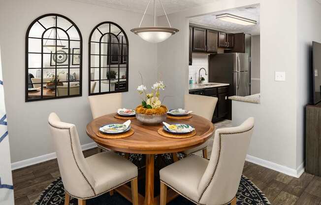 A dining room with a round wooden table and chairs.