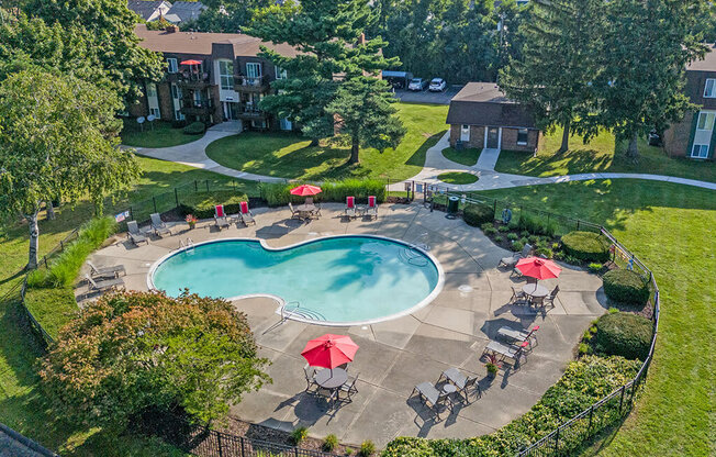 an aerial view of a swimming pool and patio with umbrellas