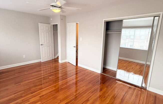 A room with wooden floors and a ceiling fan.
