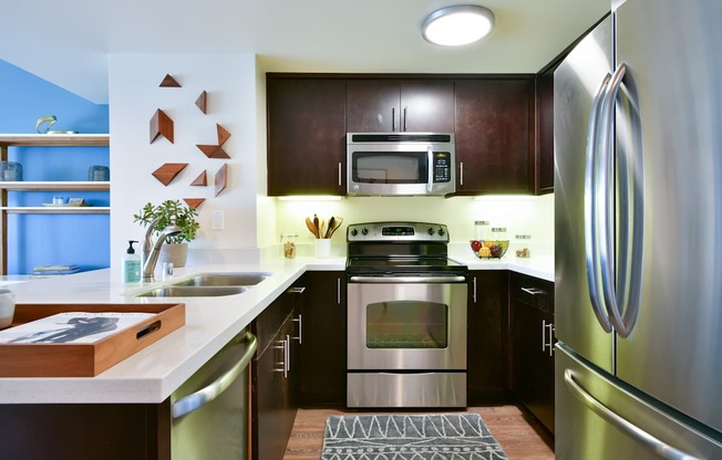 A modern kitchen with a stainless steel refrigerator and oven.