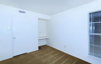 carpeted bedroom with a built-in desk