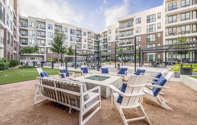 an outdoor patio with chairs and tables and an apartment building