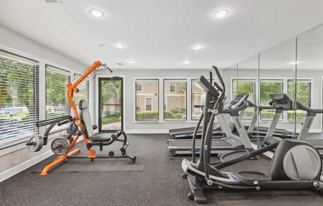 the gym has plenty of exercise equipment and windows