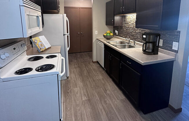a kitchen with white appliances and black cabinets