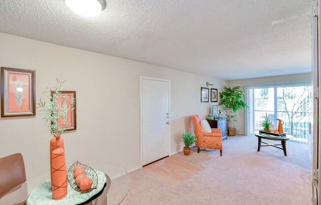 Spacious  living room with a chair and a table and a window