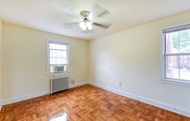 vacant bedroom with hardwood flooring and ceiling fan at colonnade apartments in washington dc