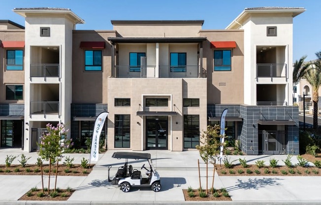 A modern building with a golf cart in front.