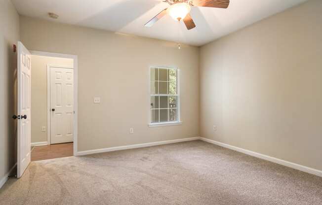 Empty bedroom with soft carpet floor and natural light at Angel Landing apartments in Pensacola, FL