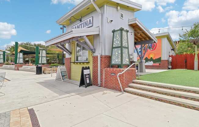 the front of a building with stairs and a sign on the sidewalk