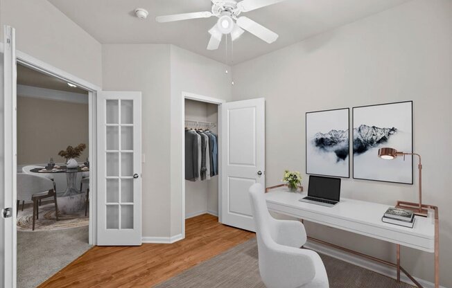 a bedroom with a desk and a closet