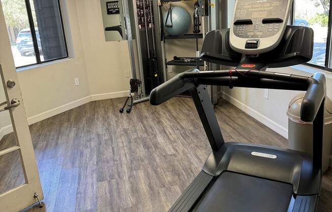 a gym with a treadmill and a chair in it