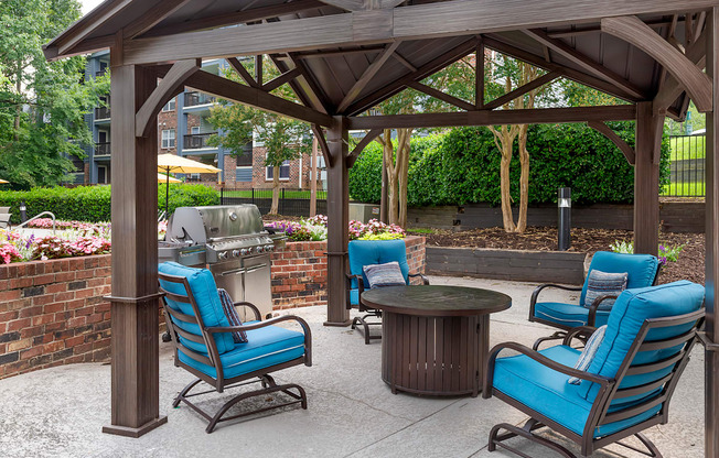 a patio with chairs and a grill and a table