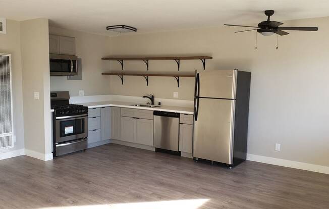 Kitchen Area with Shelf Units, White Countertops, Stainless Steel Appliances, Hardwood Flooring at Wilson Apartments in Glendale, CA