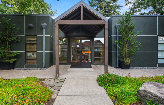 A building with a wooden entrance and a stone pathway leading to it.