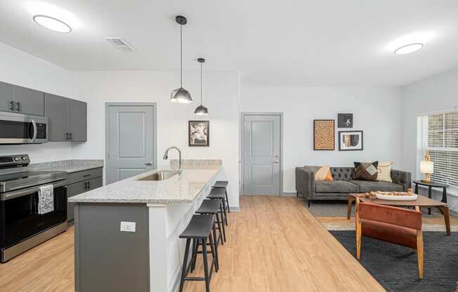 a kitchen with a long island and a living room with a couch