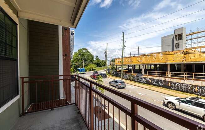 a balcony with a view of a street and a train