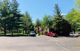 a parking lot with cars in front of a house