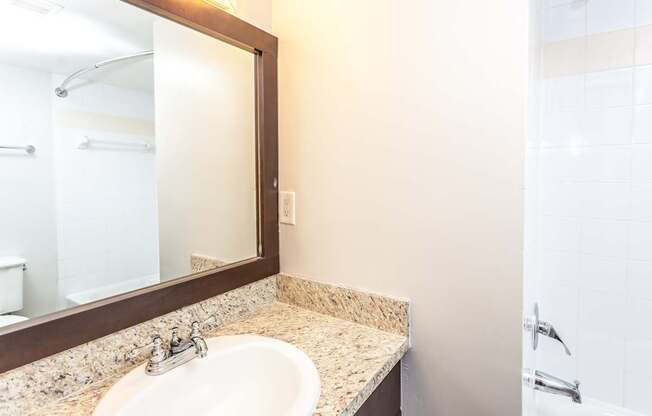 A bathroom with a sink and mirror.