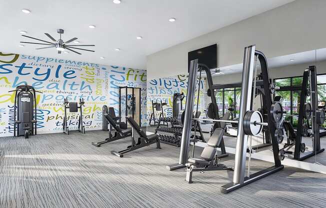 a gym with exercise equipment and a wall covered in graffiti