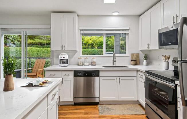 a kitchen with white cabinets and a stainless steel refrigerator