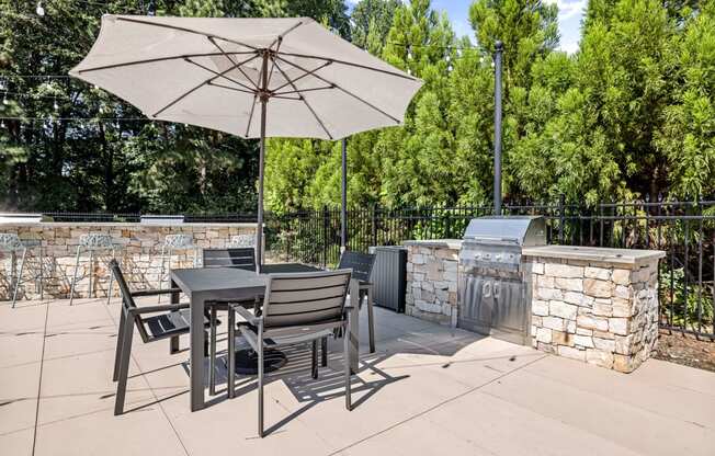 a patio with a table and chairs and an umbrella at View at Lake Lynn, North Carolina, 27613